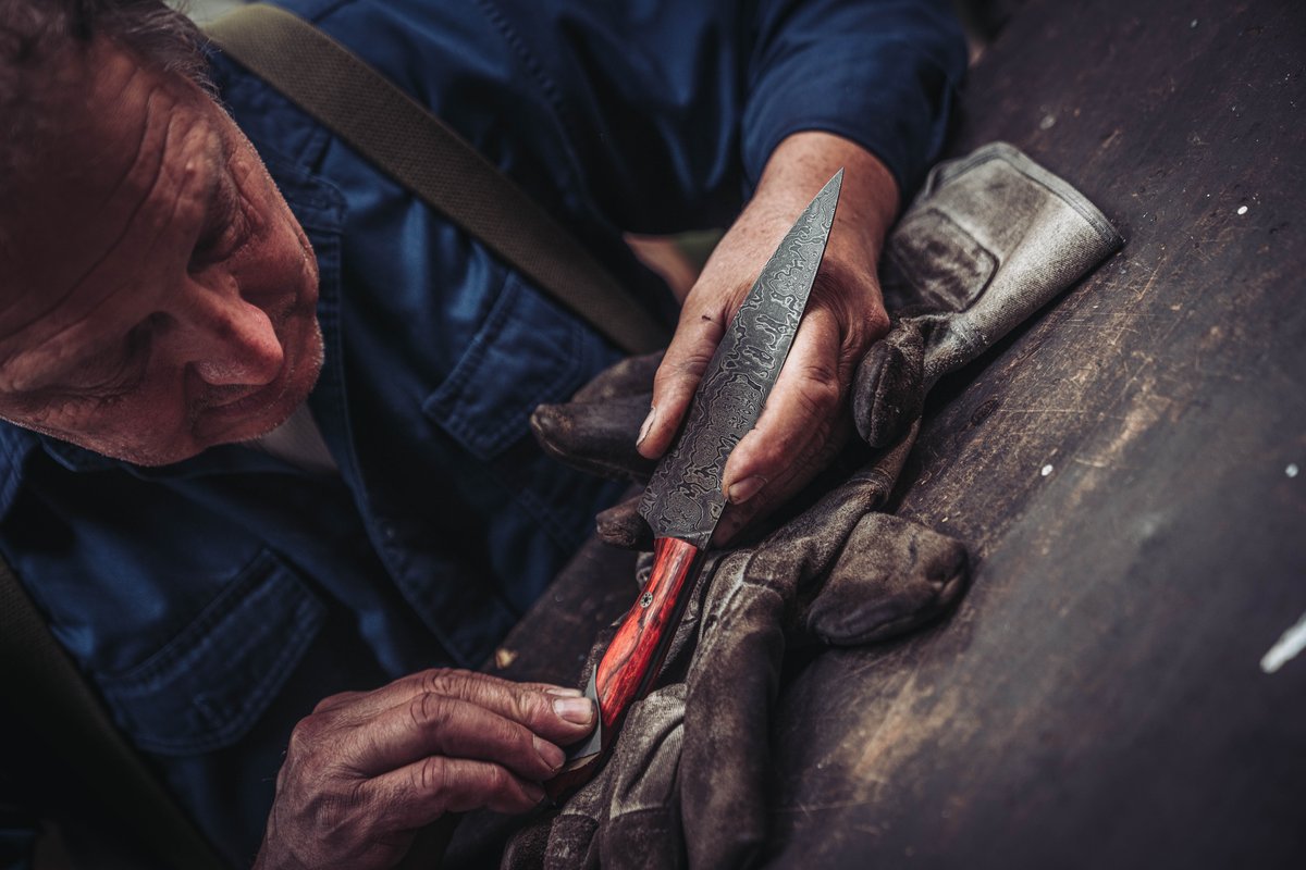 Schmied prueft die fertige Damastklinge bei der Qualitaetskontrolle