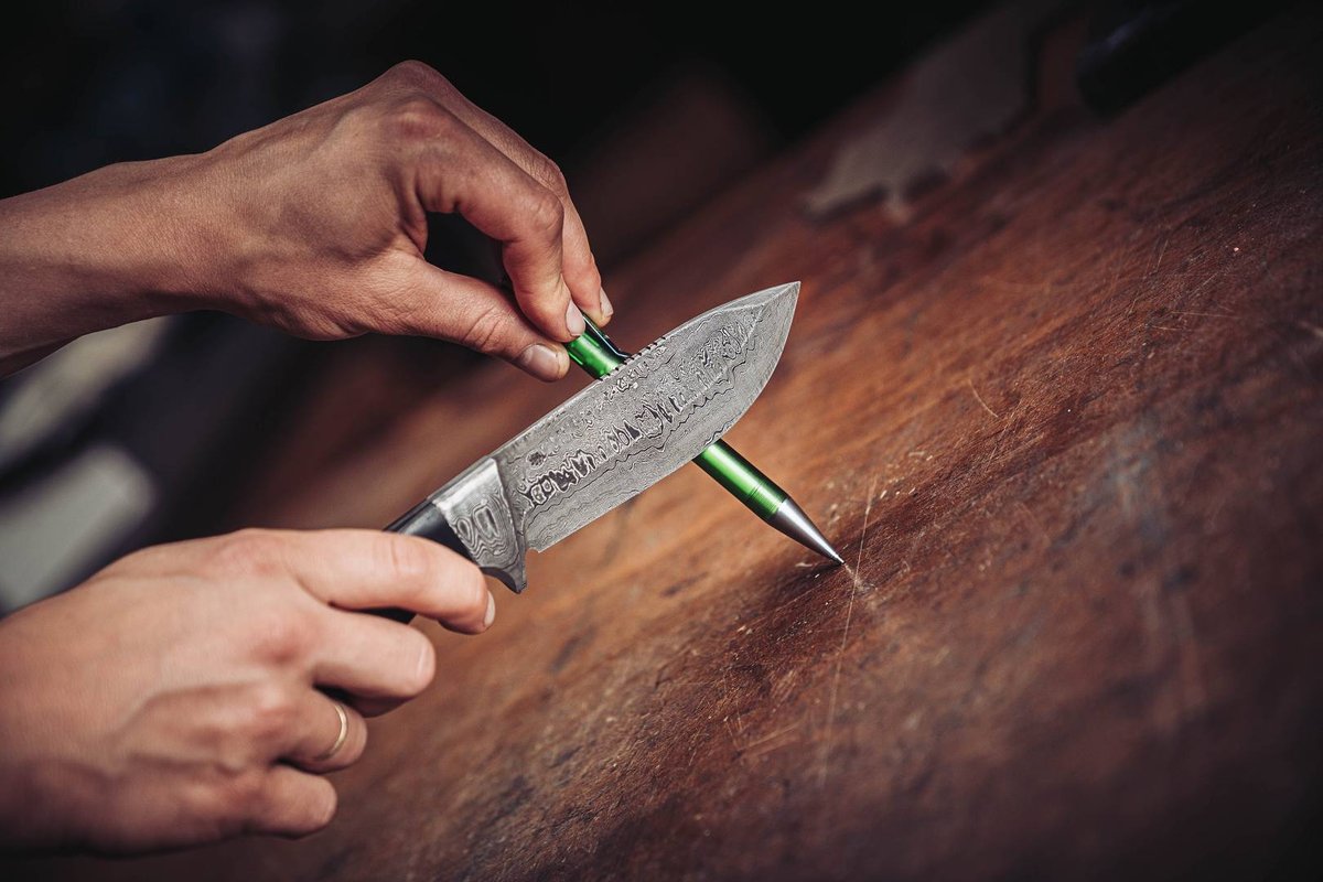 Damastklinge balanciert auf einem Kugelschreiber als Sch&auml;rfetest