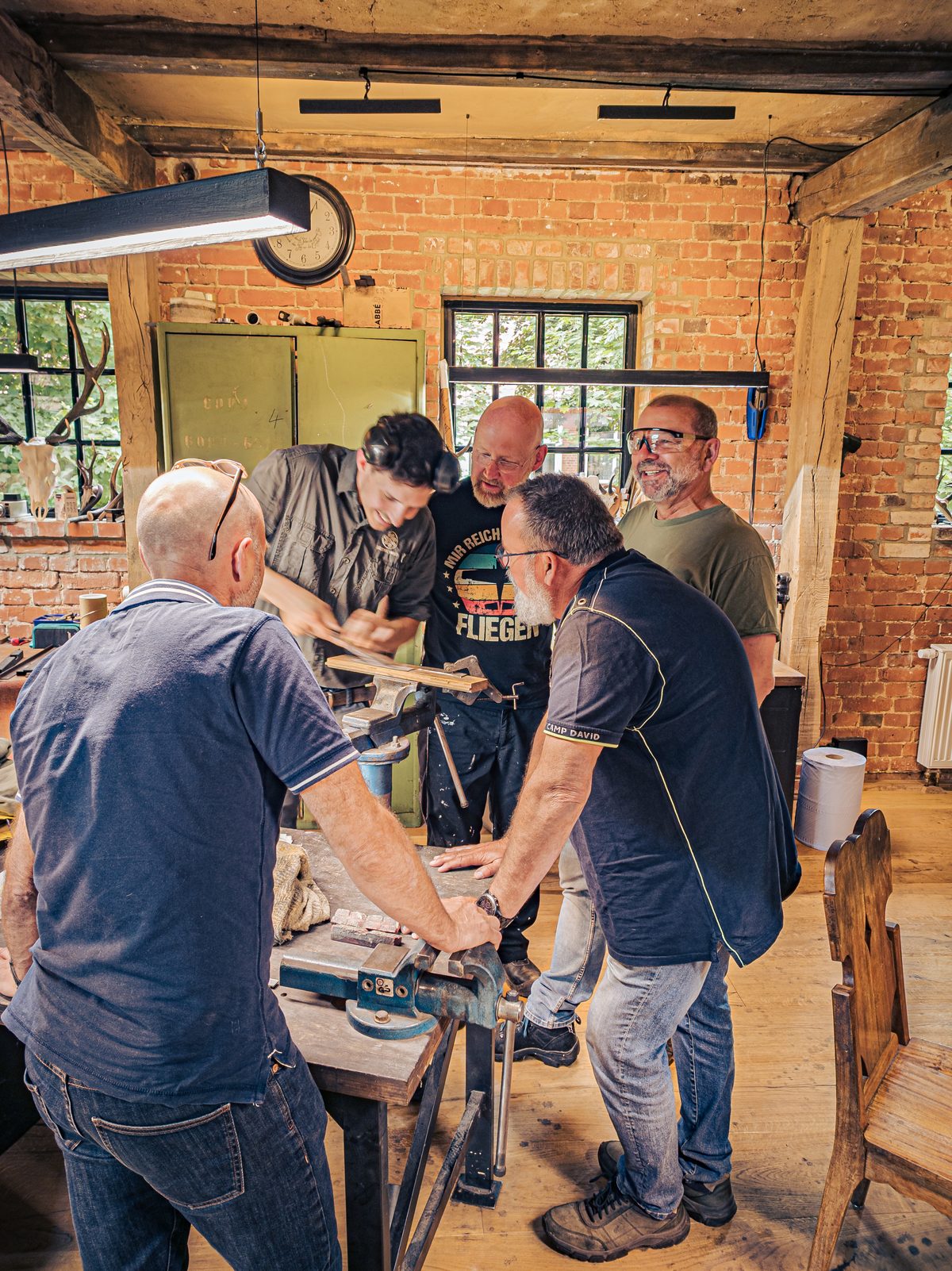 Kursteilnehmer gemeinsam am Werkstisch in der Moorschmiede
