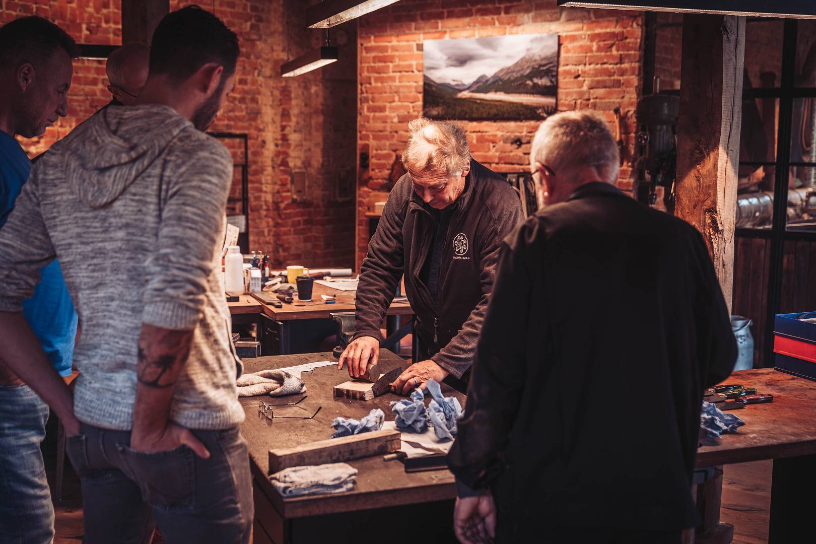 Wolf Schr&ouml;ppe erkl&auml;rt Kursteilnehmern die Technik an der Werkbank &mdash; Schmiedekurs Moorschmied