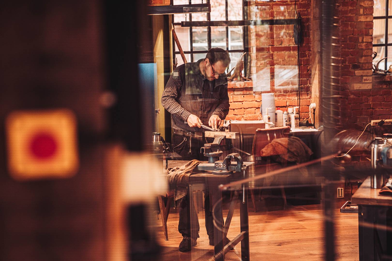 Schmied bei der Arbeit in der Werkstatt der Moorschmiede &mdash; Backsteinw&auml;nde, warmes Licht, konzentrierte Handarbeit