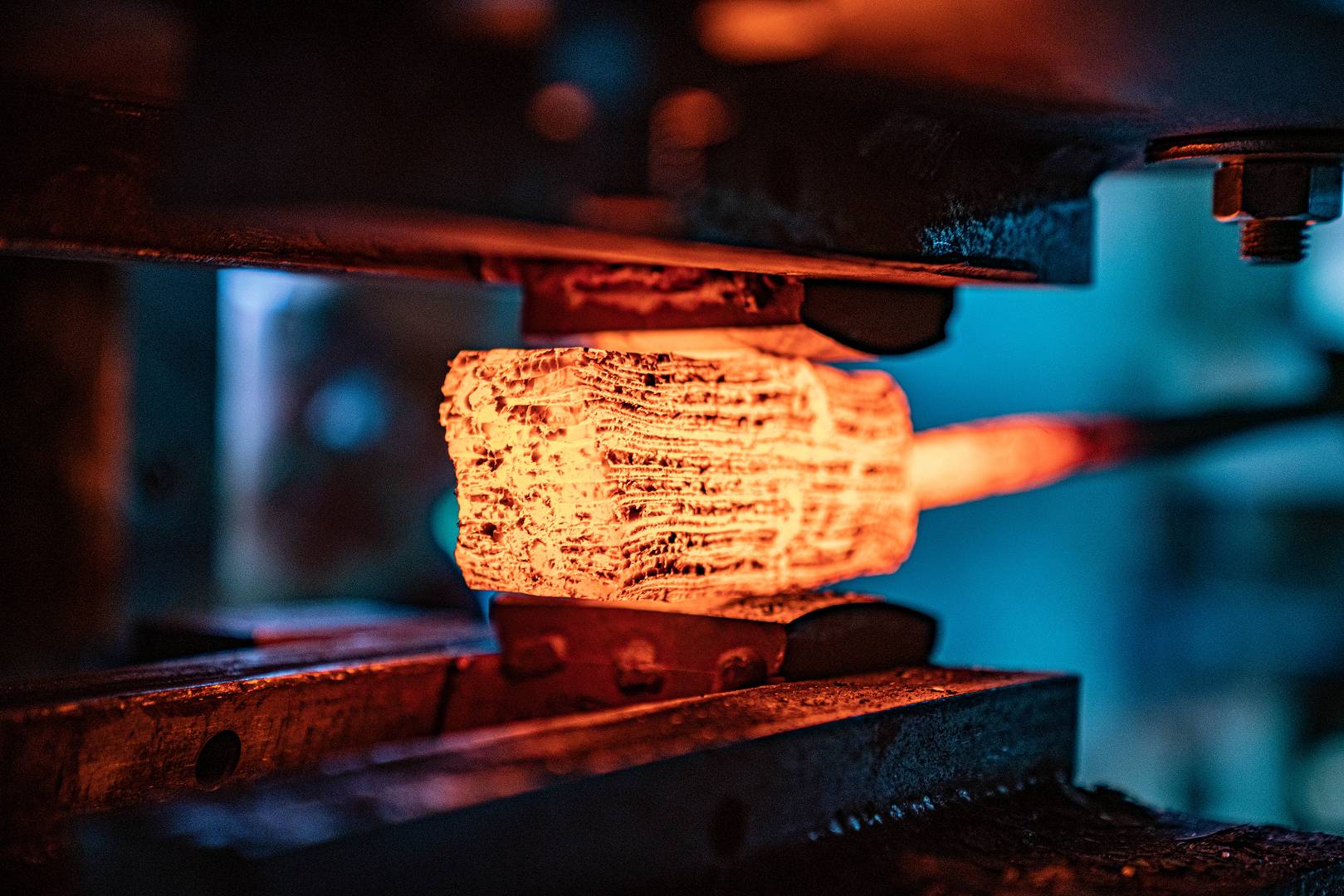 Gl&uuml;hendes Damastpaket im Federhammer beim Feuerverschwei&szlig;en