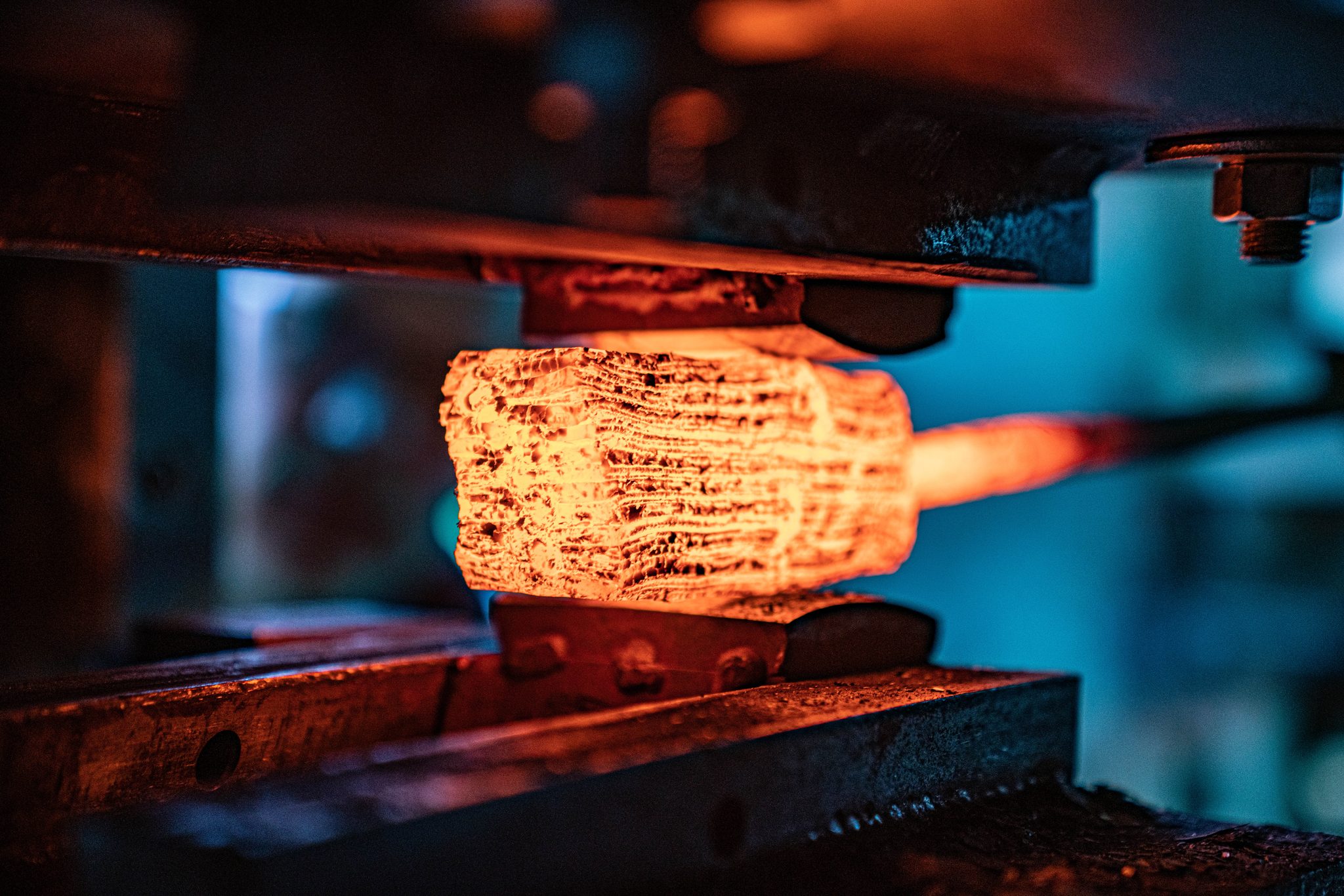 Gl&uuml;hender Damaststahl wird im Gesenk der Hydraulikpresse geformt &mdash; 1.200 Grad Celsius