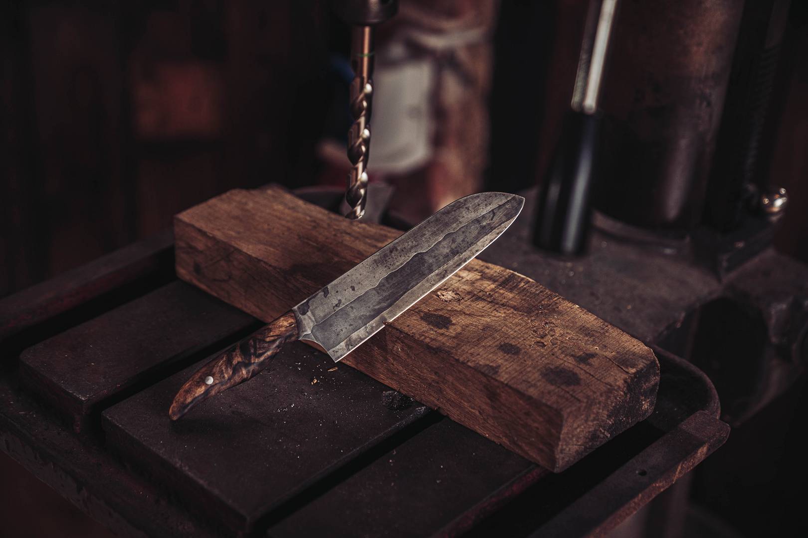 Handgeschmiedetes Messer mit Holzgriff auf der Werkbank &mdash; bereit f&uuml;r den neuen Besitzer