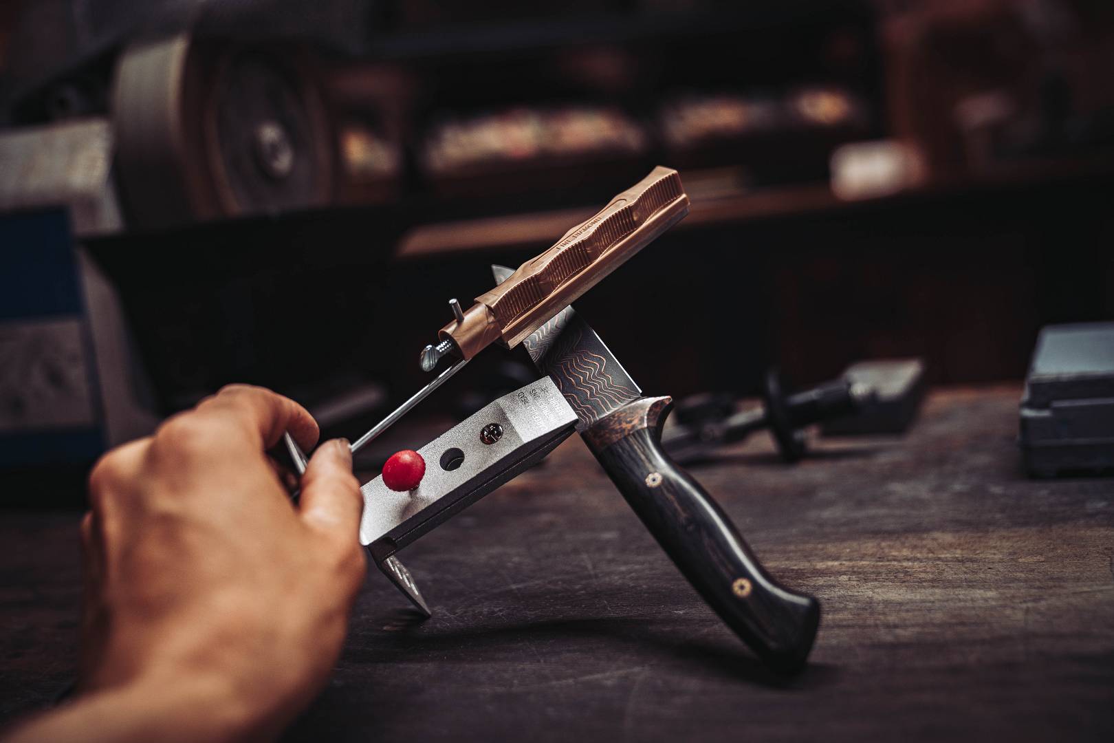 Kupferdamast-Klappmesser in der Montage &mdash; Klinge mit Kupfermuster wird in Klemme gehalten