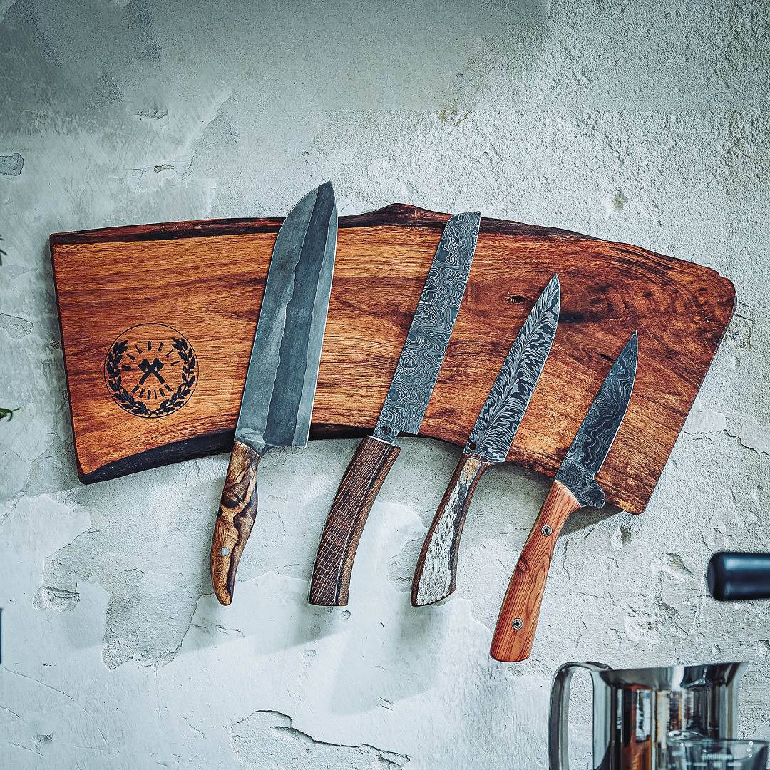 F&uuml;nf handgeschmiedete Damastmesser an einem Magnethalter aus Walnussholz mit Moorschmied-Logo